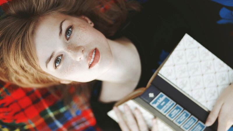 woman with freckles reading book