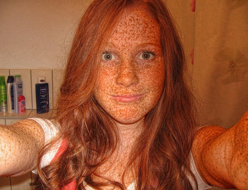woman with freckles taking selfie