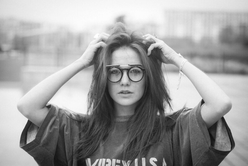 woman with glasses adjusting hair