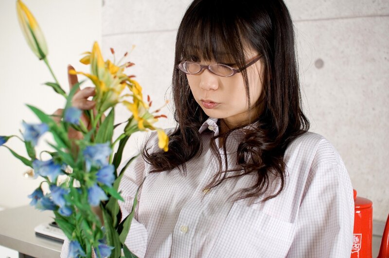 woman with glasses arranging flowers
