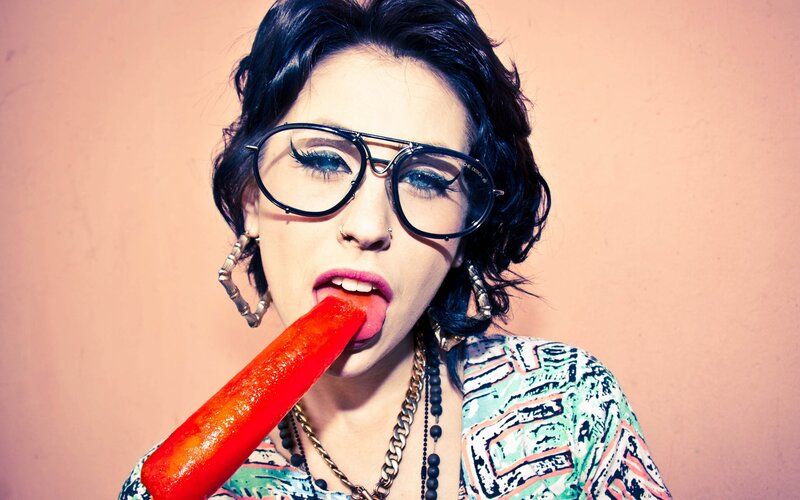 woman with glasses eating popsicle