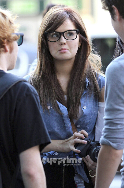 woman with glasses holding camera