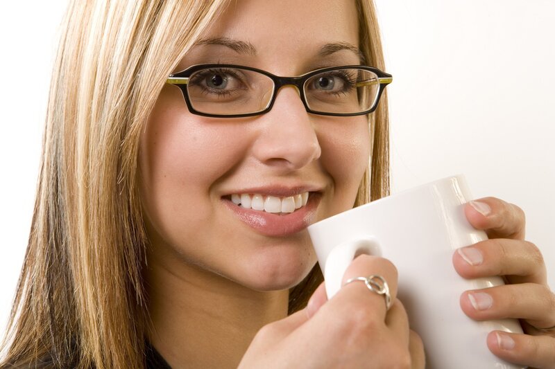 woman with glasses holding mug