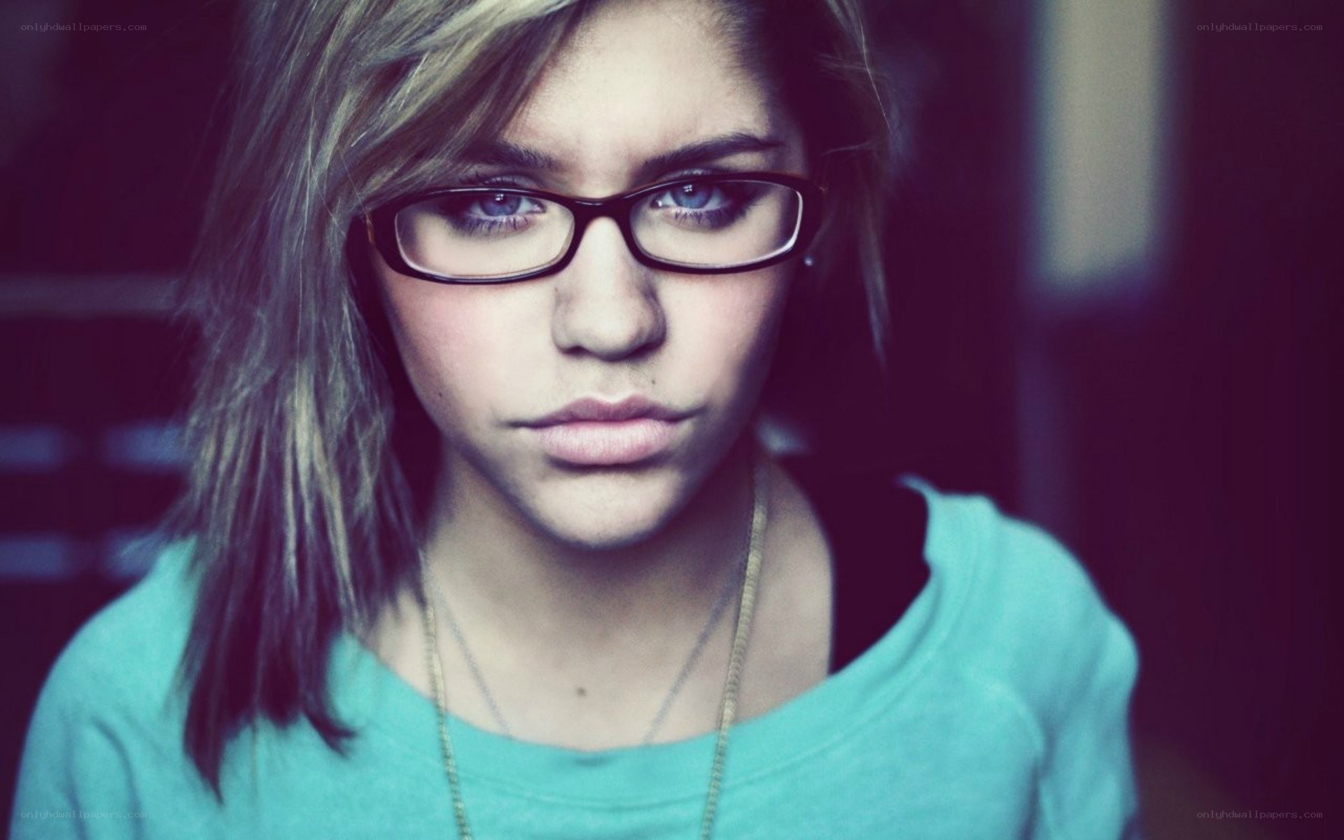 woman with glasses looking at camera