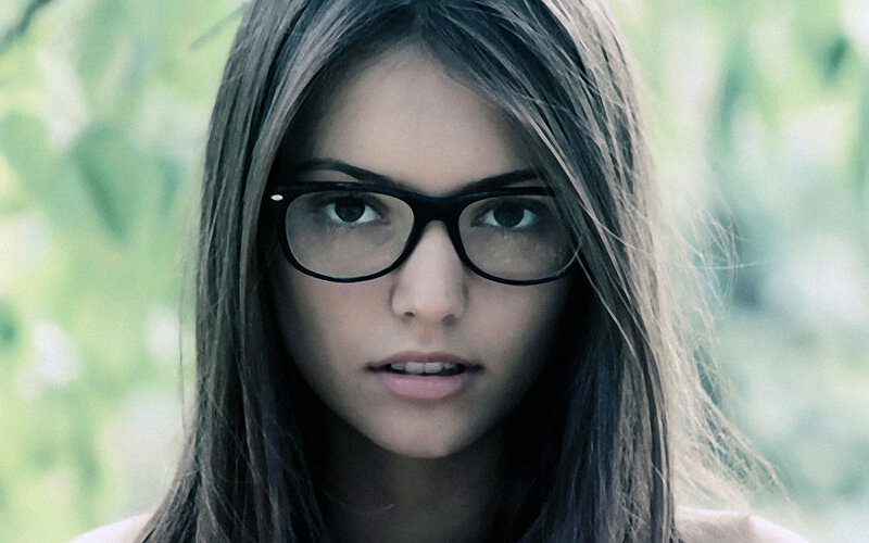 woman with glasses looking at camera