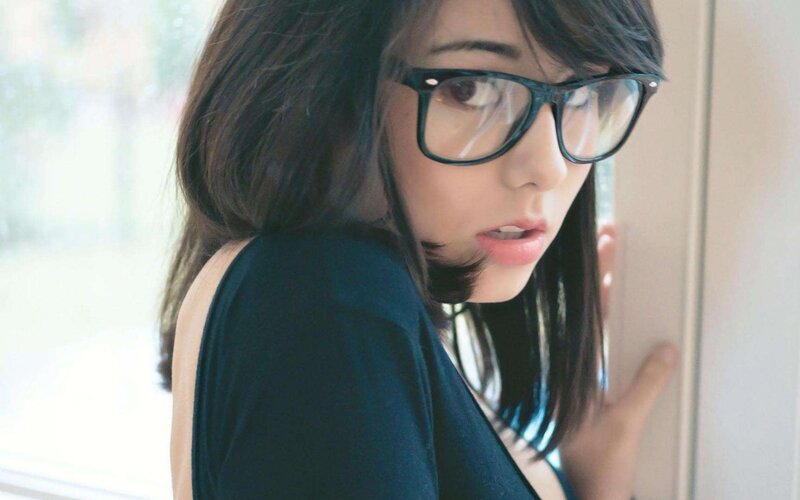 woman with glasses looking over shoulder