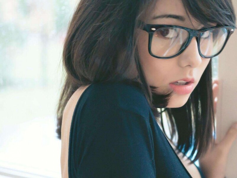 woman with glasses looking over shoulder