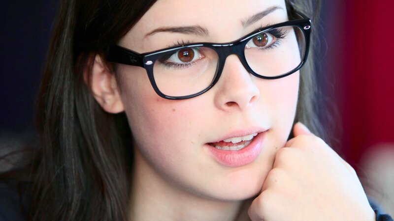 woman with glasses looking thoughtful