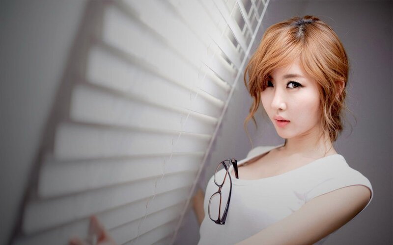 woman with glasses near blinds