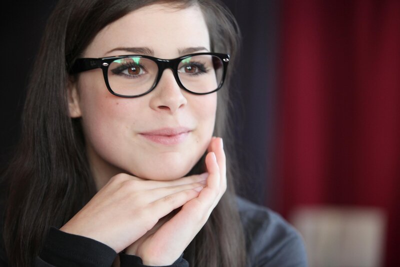 woman with glasses resting chin
