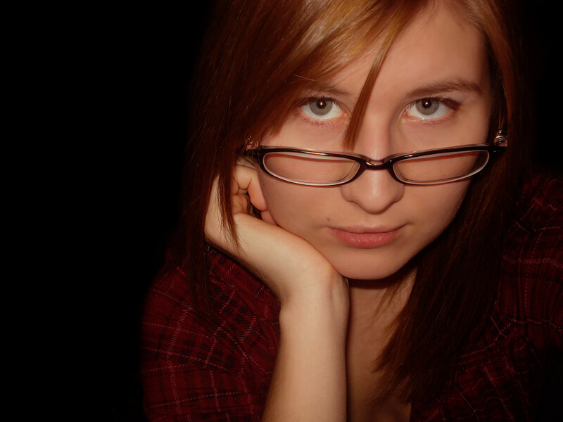woman with glasses resting chin