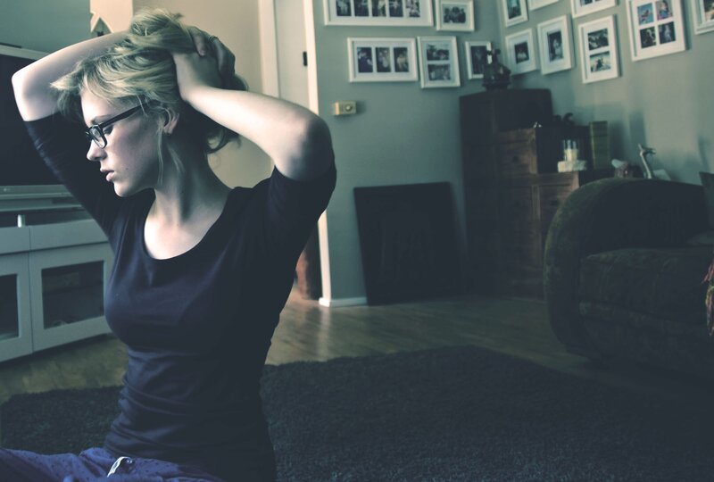woman with glasses sitting on floor
