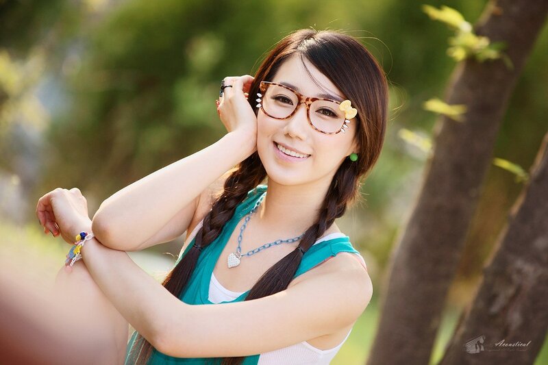 woman with glasses smiling outdoors