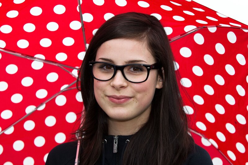 woman with glasses under polka dot umbrella