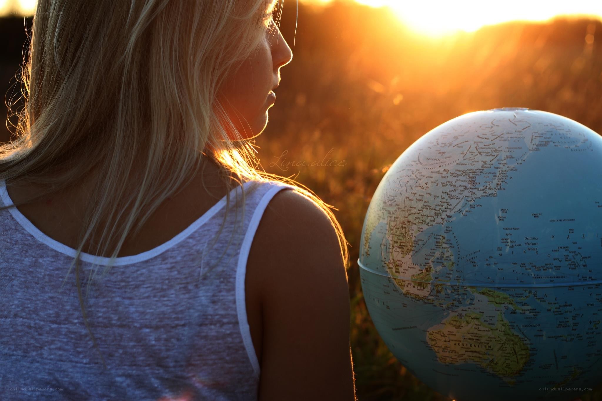 woman with globe at sunset