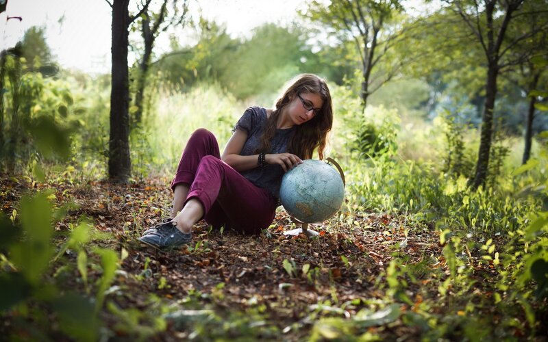 Woman with globe in forest