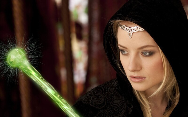 woman with glowing green staff