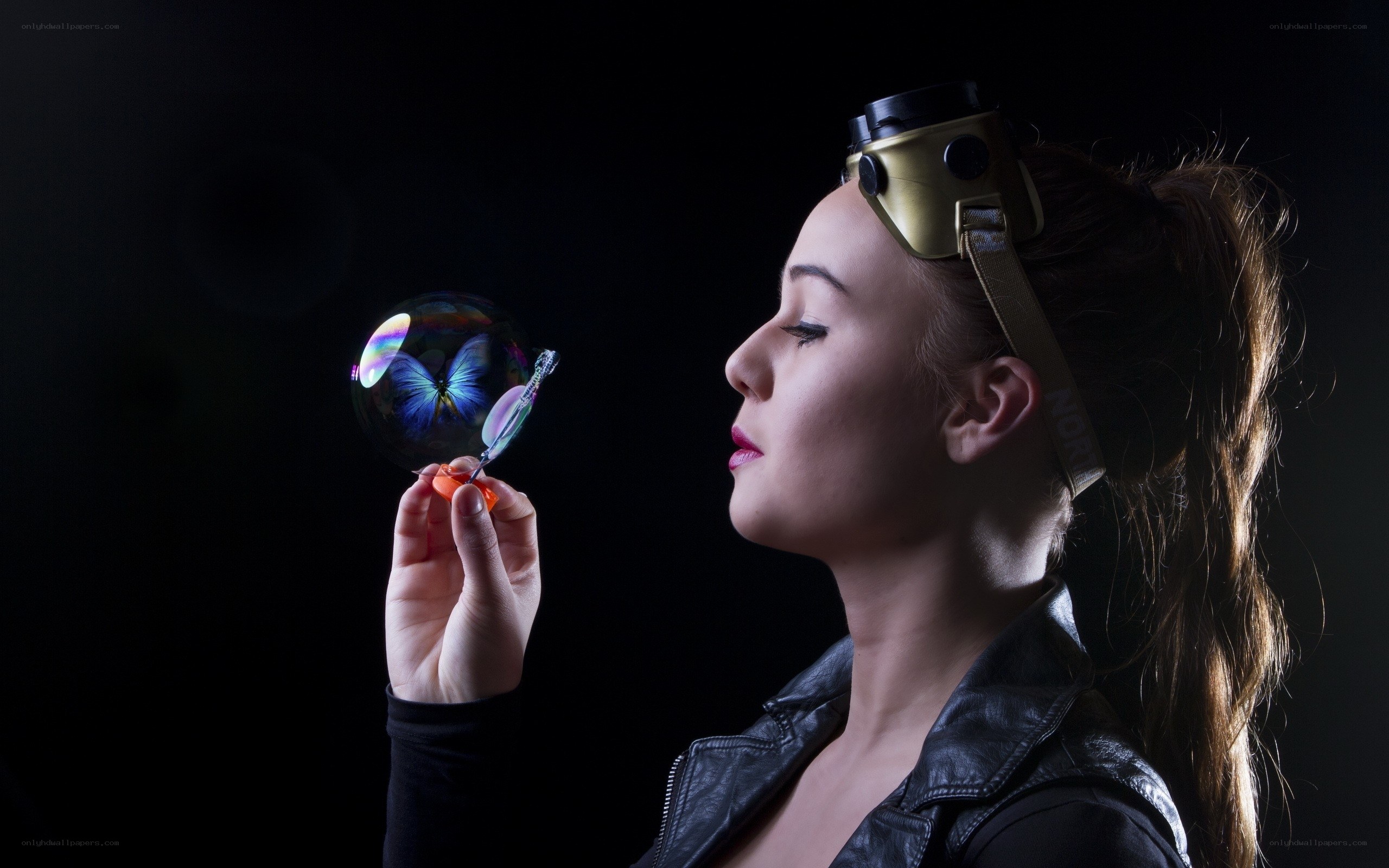 woman with goggles blowing a bubble