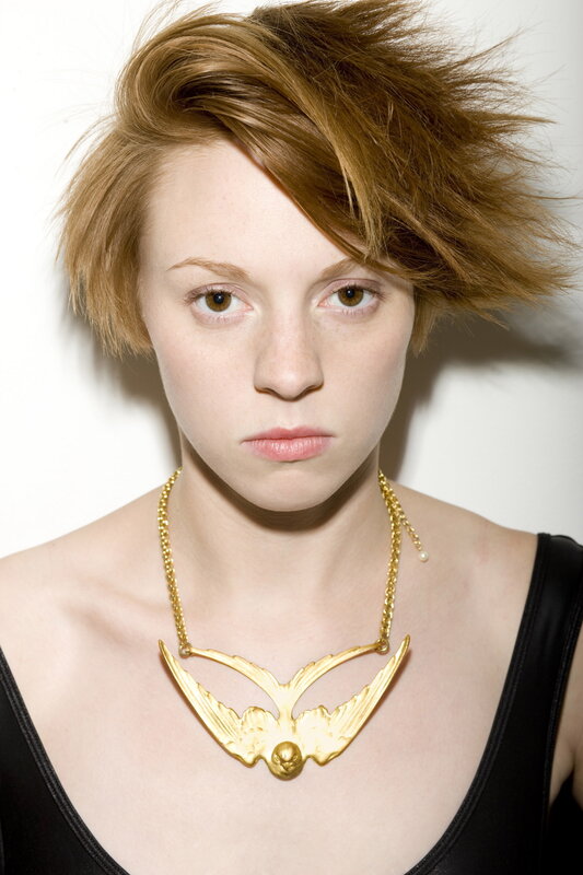 woman with gold bird necklace