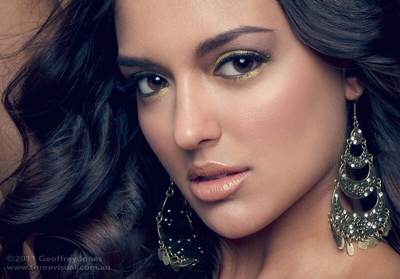 woman with gold makeup and earrings