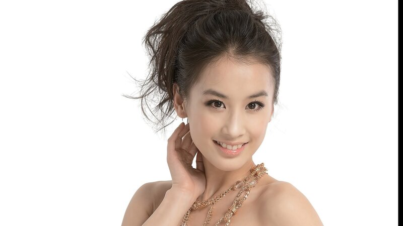 woman with gold necklace smiling