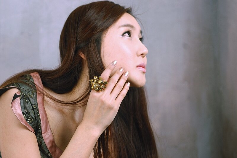 woman with gold ring touching face