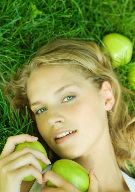 woman with green apples on grass