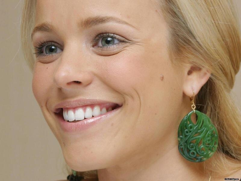 woman with green earrings smiling