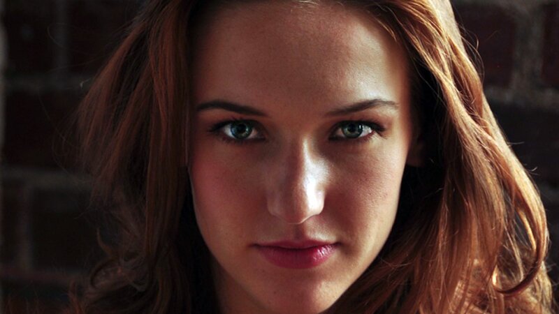Woman with Green Eyes — Brown, Intense, Photograph, Brick Wall