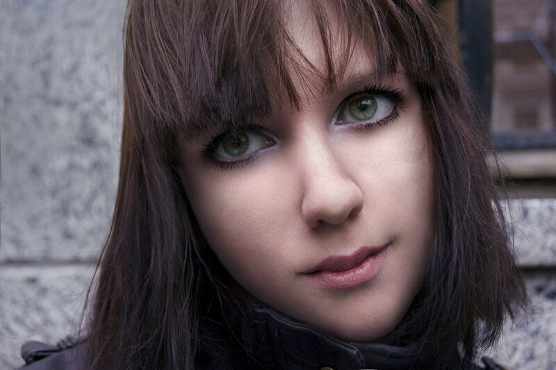 Woman with Green Eyes — Brown, Serious, Photograph, Stone Wall