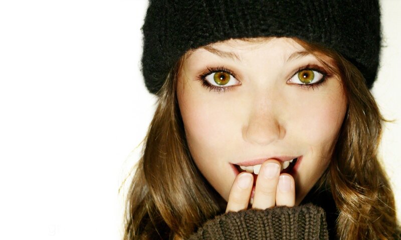 woman with green eyes covering mouth