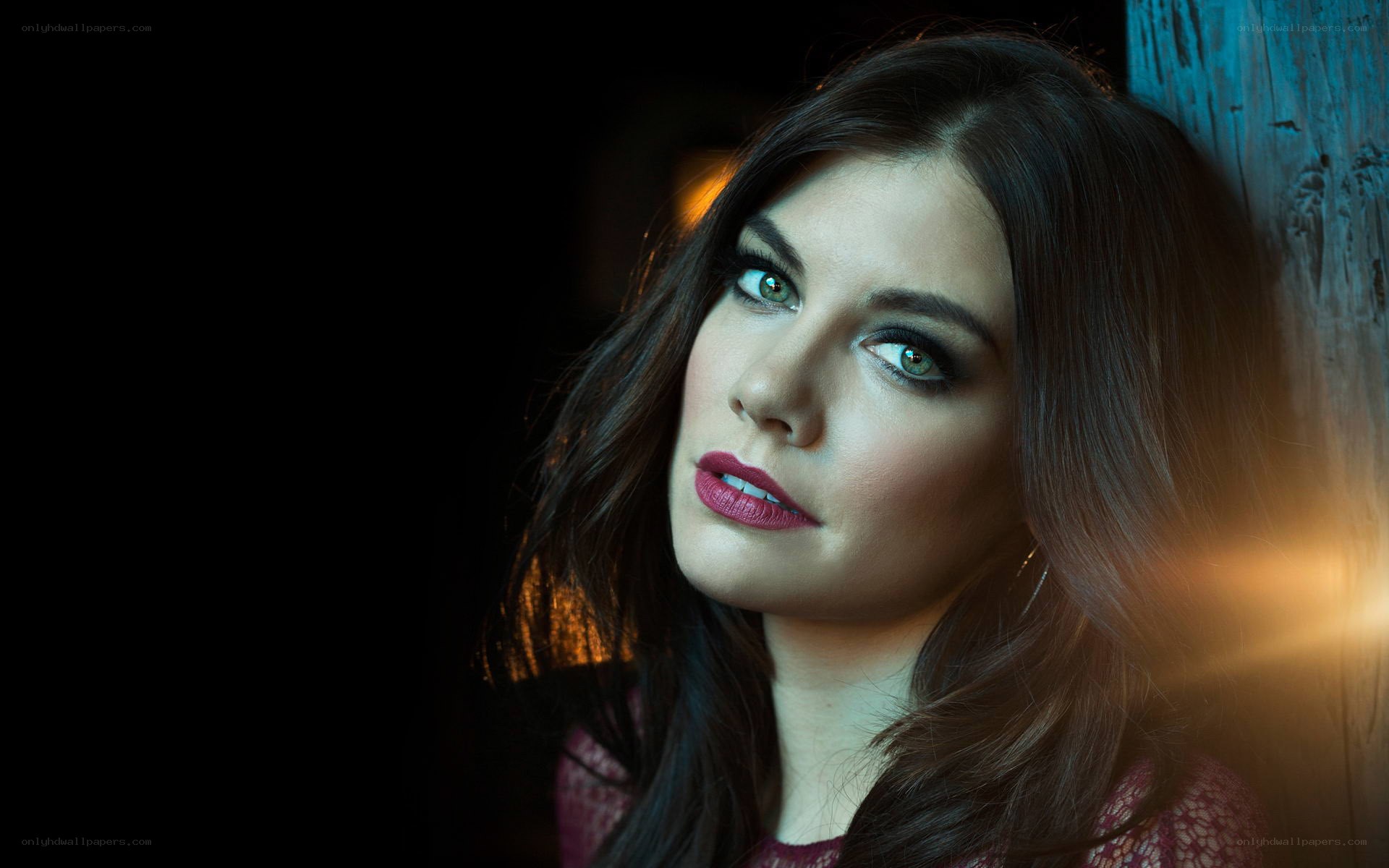 woman with green eyes leaning against wall
