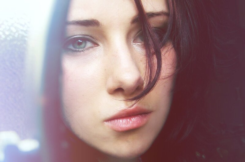 woman with green eyes looking out window