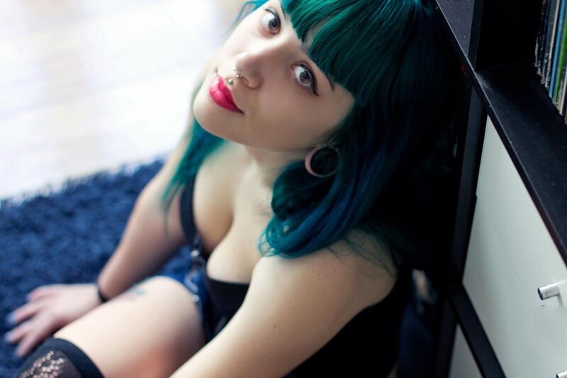 woman with green hair sitting on floor