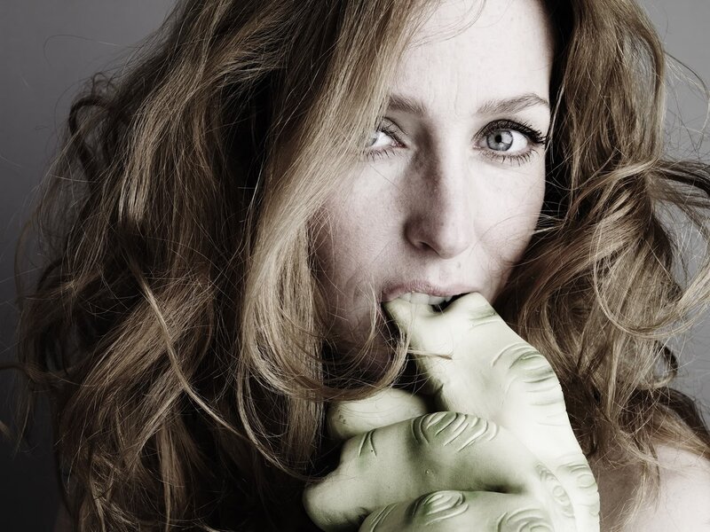 woman with green hand sculpture