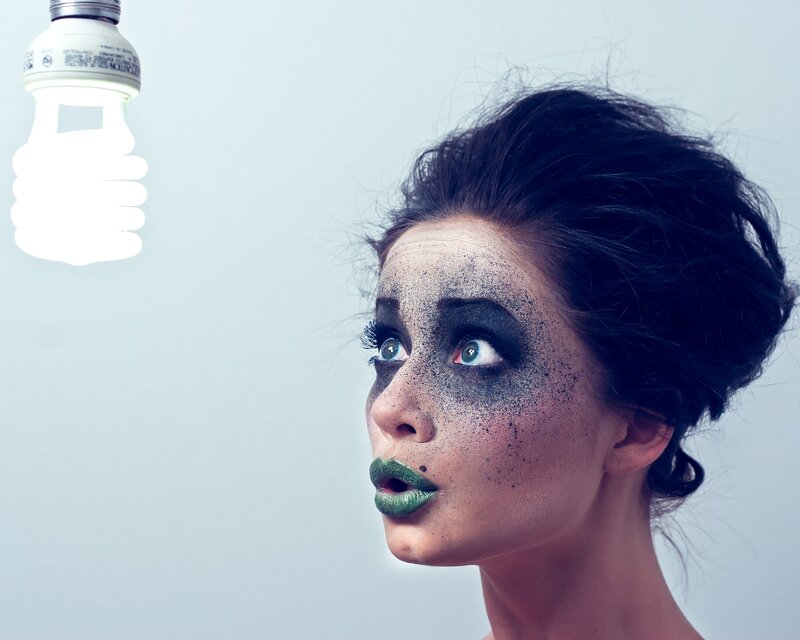 woman with green makeup and light bulb