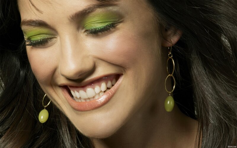 woman with green makeup smiling