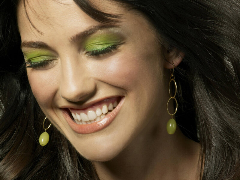 woman with green makeup smiling