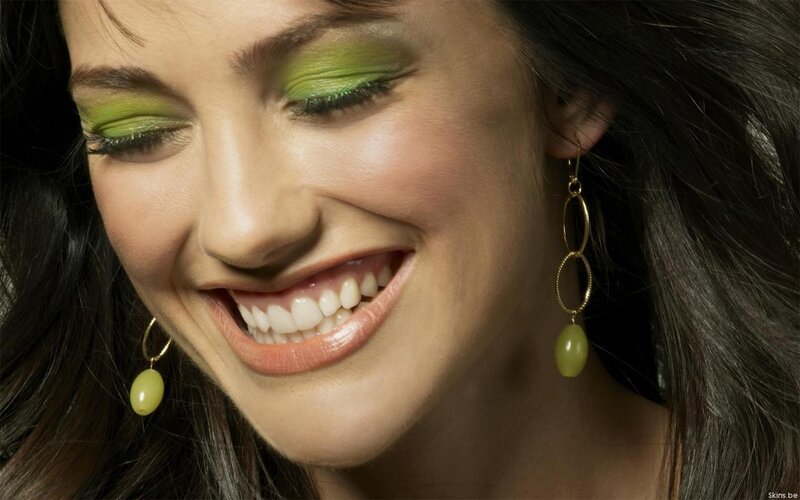 woman with green makeup smiling