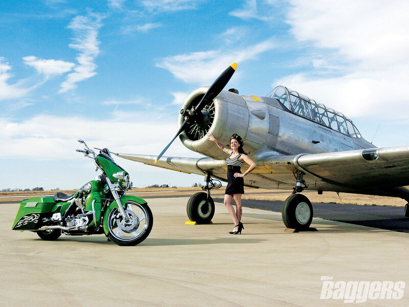 Woman with green motorcycle and plane