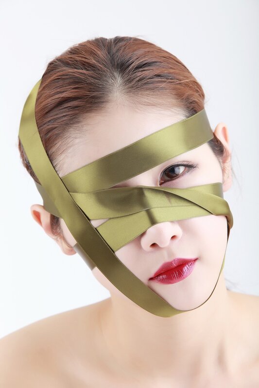 woman with green ribbon mask