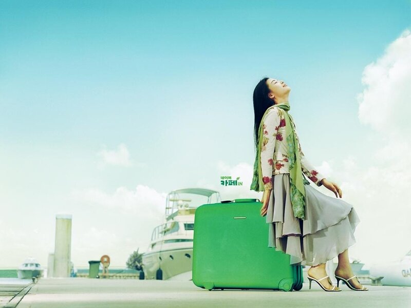 Woman with green suitcase at dock