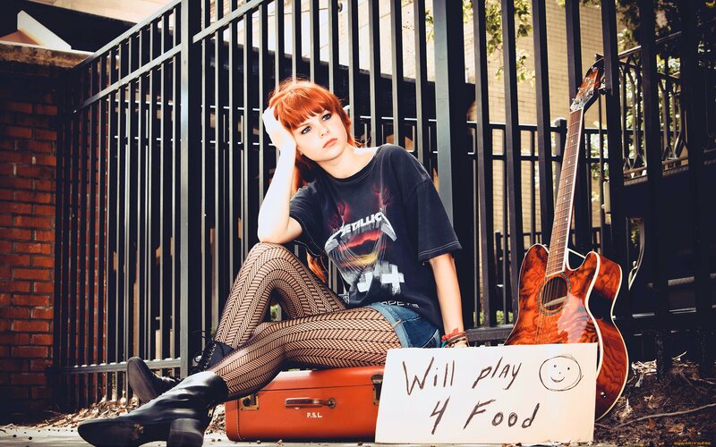 woman with guitar and sign