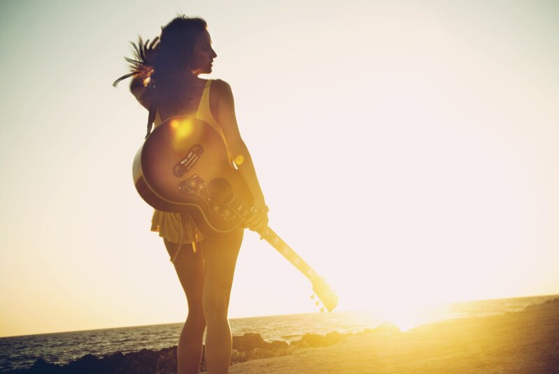 woman with guitar at sunset