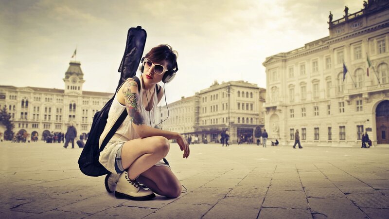 woman with guitar case in square
