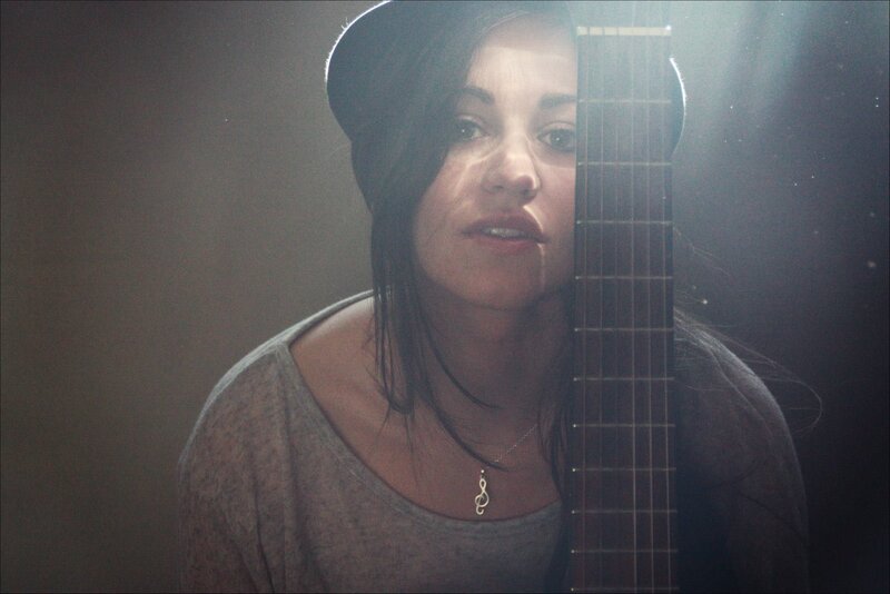 woman with guitar in dim light