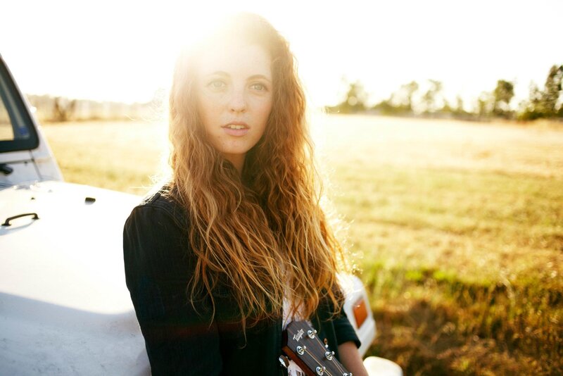 woman with guitar in field