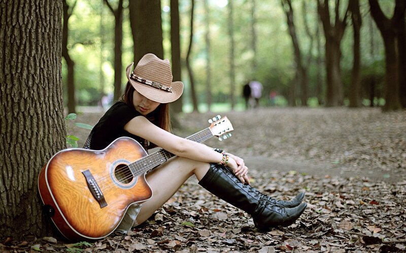 Woman with guitar in forest