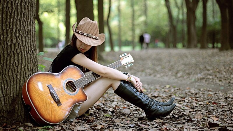 Woman with guitar in forest