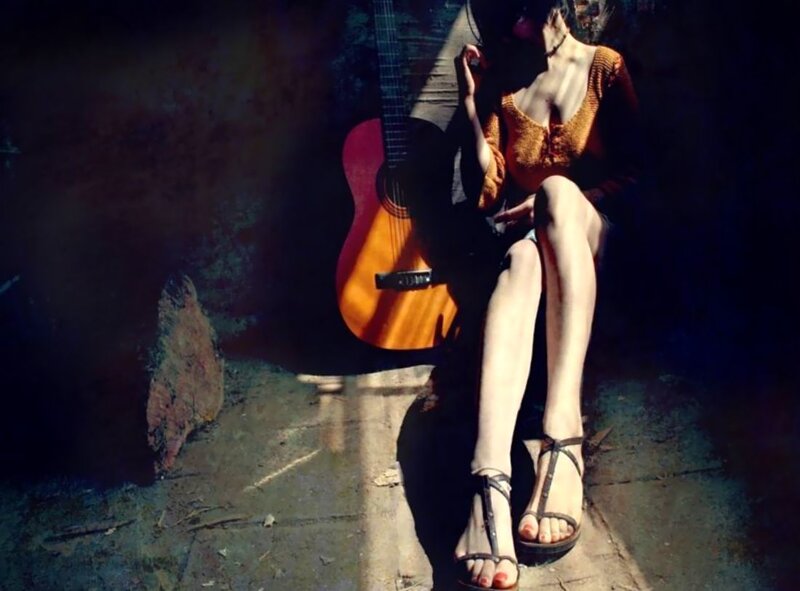 Woman with guitar in sunlight